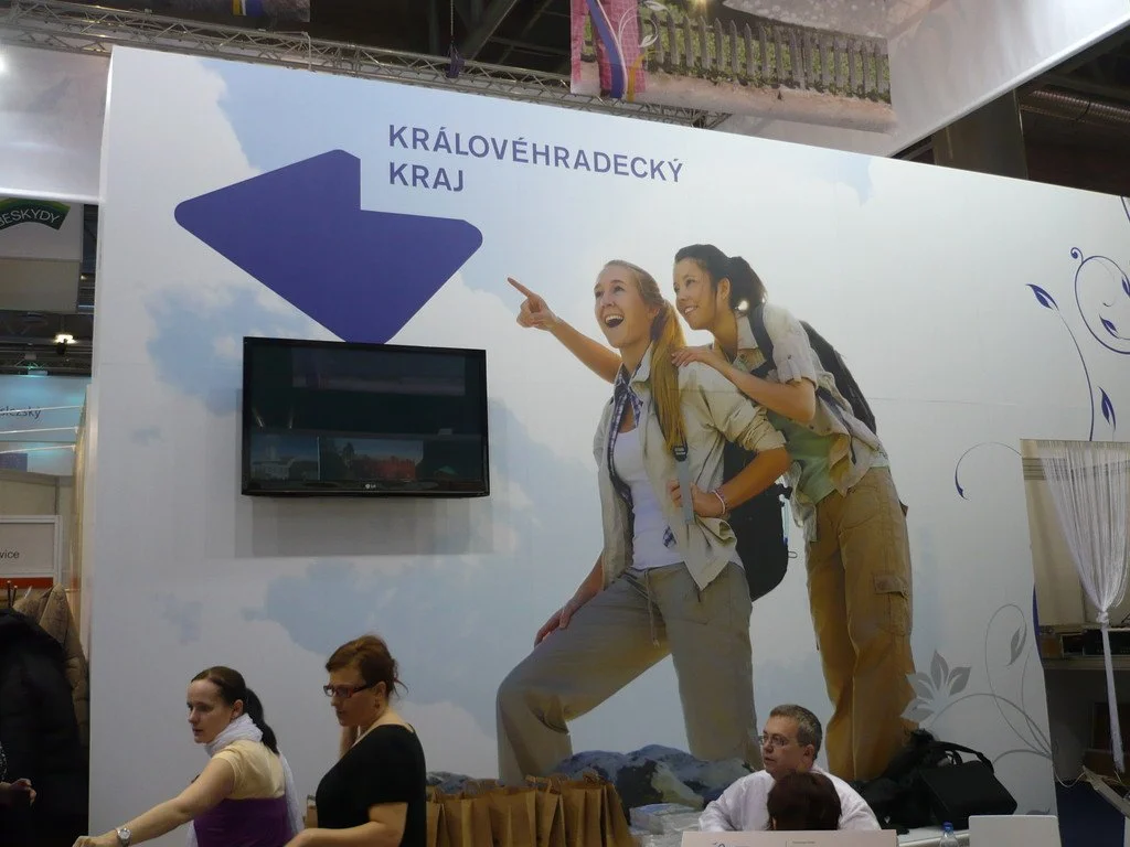 Velkoformátový banner Královéhradeckého kraje s turistkami na stěně stánku