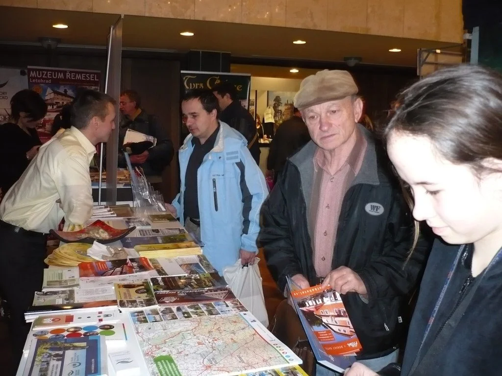 Návštěvníci u stánku s prospekty před bannery Muzea řemesel a Tvrze Orlice