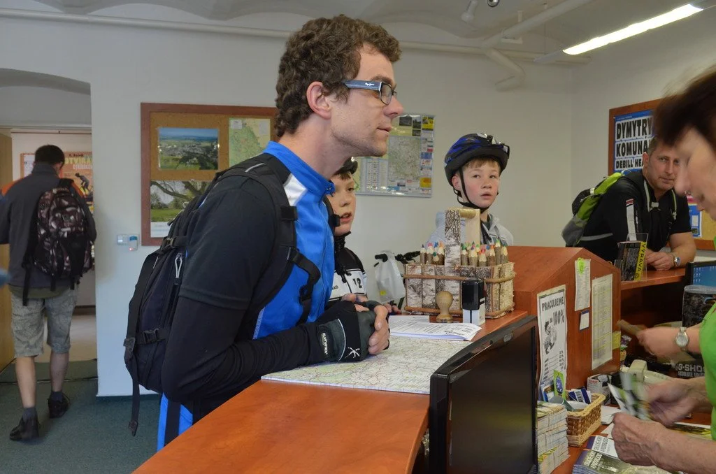 Cyklista s batohem u přepážky informačního centra