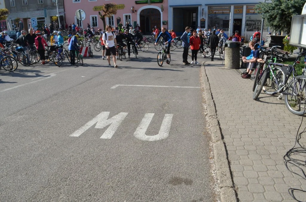Cyklisté se shromažďují na náměstí před hospodou s pivovarem