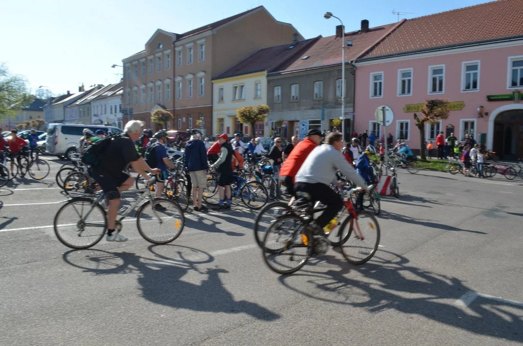 Cyklisté na náměstí před historickými domy