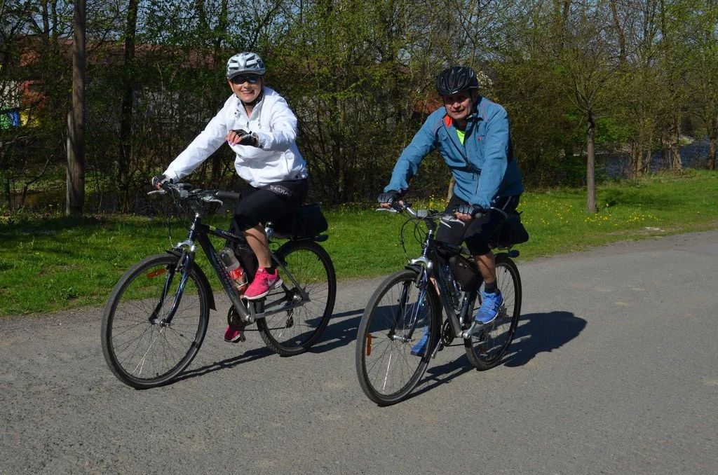 Usmívající se dvojice cyklistů pózuje na kole