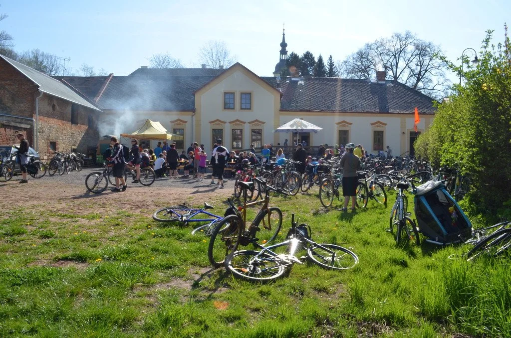 Cyklisté s koly odpočívají na nádvoří historické budovy