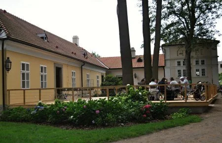 Terasa se zahradním posezením u zámecké budovy a záhony hortenzií
