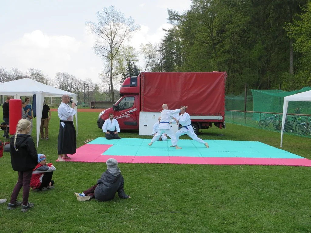 Ukázka aikida na trávníku před hasičským vozem a stany