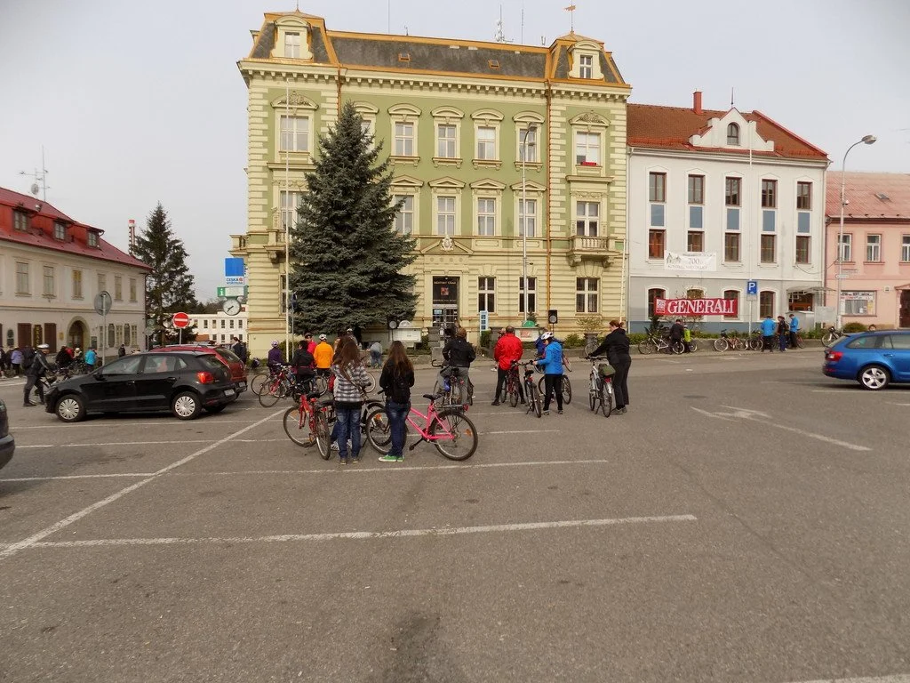 Cyklisté na náměstí před historickou budovou radnice