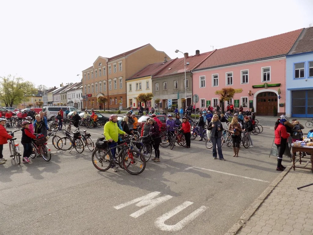 Cyklisté s koly na náměstí s barevnými historickými domy