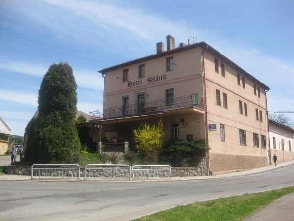 Budova Hotelu Sláme s terasou a vzrostlým jehličnanem před vchodem
