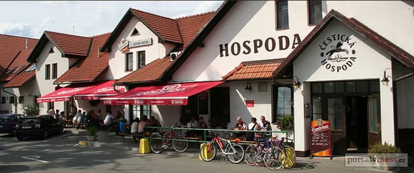 Hospoda s venkovní terasou, slunečníky a odstavenými koly