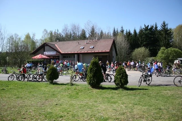 Cyklisté odpočívají u restaurace s parkovanými koly
