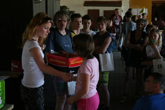 Žena předává dítěti krabici s nápisem Author v hale