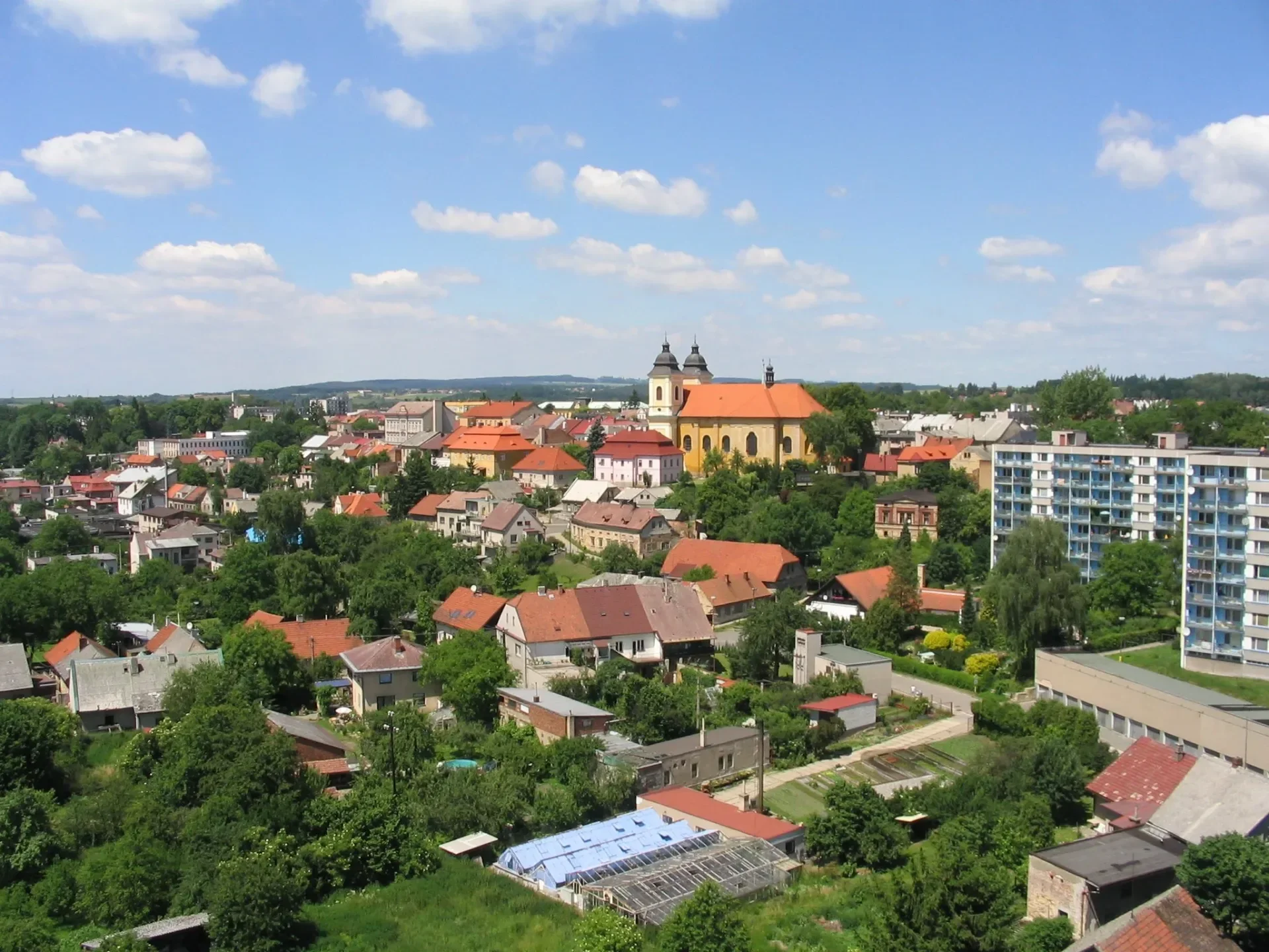 Pohled na město s věžemi kostela a červenými střechami domů
