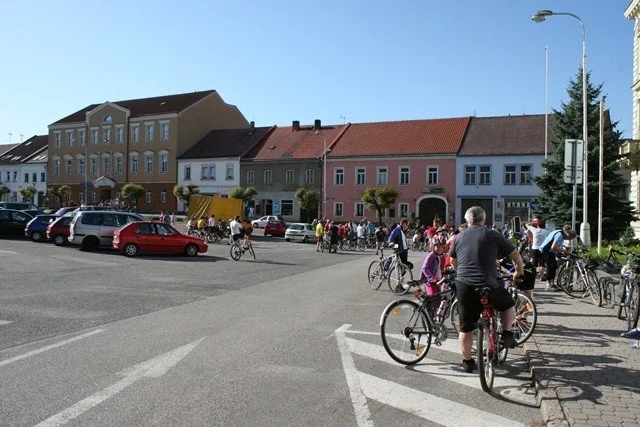 Cyklisté se srocují na náměstí s barevnými historickými domy