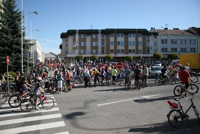 Velká skupina cyklistů se shromažďuje na křižovatce v centru města