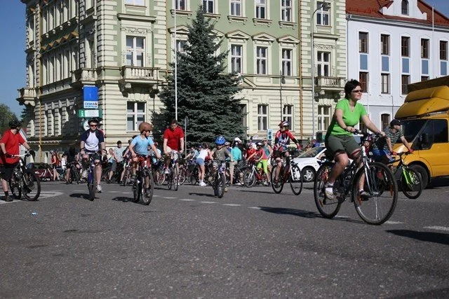 Cyklisté projíždějí náměstím kolem historických budov